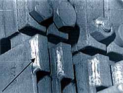 Fig.7. Cracked burst can detector hanger welds. Arrow shows location of crack.