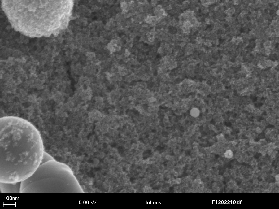 Fig. 8 The surface of a 6 nm coatings produced in a Ar/H<sub>2</sub> plasma with the dense packing of fine agglomerates (ca. 50 nm) that make up the majority of the coating. Also visible is a number of small melted agglomerates ca. 0.5 µm in size.