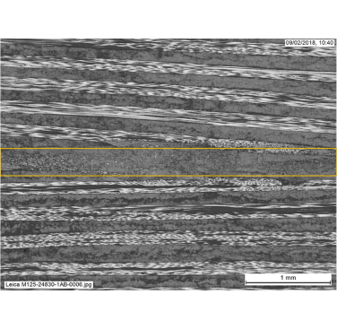 Figure 3. Linear friction weld in continuous carbon fibre/PEEK composite (yellow lines denote weld location)