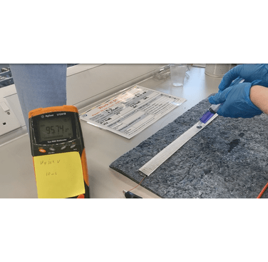 Figure 11. Example of hydraulic test. The Wrapsense sensor (white) is laid over the spill blanket and connected to the multimeter using clamps. A reading of 95.74 kOhm is displayed