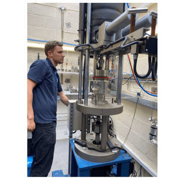 Figure 8. Lowering the pressure vessel down over the CT specimen, loaded and instrumented for testing