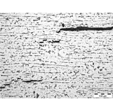 Figure 7. Hydrogen induced cracking viewed under optical microscopy. The image shows a microstructure containing a significant number of laminar inclusions which act as nucleation sites for HIC. Distortion of the microstructure caused by the cracking can be seen, along with step-wise crack growth, which is characteristic of HIC