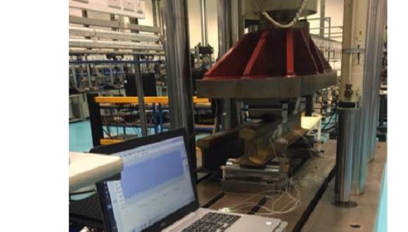 Experimental setup using a four-point bending test rig to validate the sensitivity of the sensors