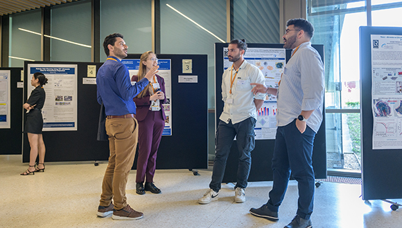 Georgios Kampourakis (right) and Fivos Simopoulos (centre right) in conversation with fellow NSIRC students at the NSIRC Research and Innovation Conference 2023. Photo: TWI Ltd / Simon Condie Photographer