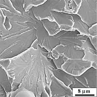 Fig.16b) Magnified view of the initiation area. The arrow indicates the likely initiation point at the grain-boundary 