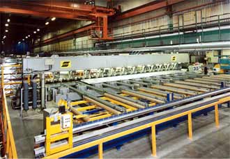 Fig.2. Friction stir welding gantry at SAPA, Sweden, including three welding heads. Also shown are the material handling conveyors for in-feeding of extruded profiles and out-feeding of straight or curved panels. The panels are used within the shipping and offshore industries and for rail vehicle production
