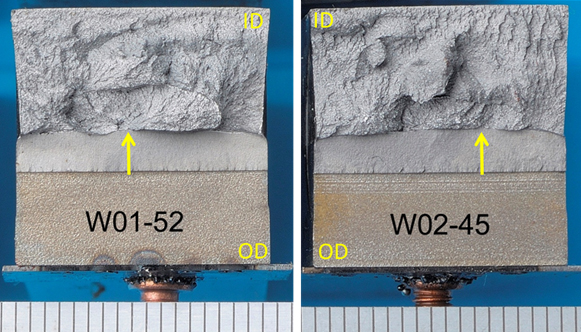 Figure 8. Fracture surfaces of specimens W01-52 and W02-45 with oval-shaped pop-ins with a fracture morphology shiny and facetted, outlined by a thin line of stable tearing. Scale is mm. Arrows show the initiation positions and planes of sectioning. T