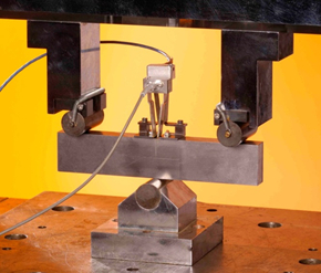 Figure 2 Fracture mechanics test (‘CTOD test’) of a single edge notched bend specimen instrumented with a double clip gauge.