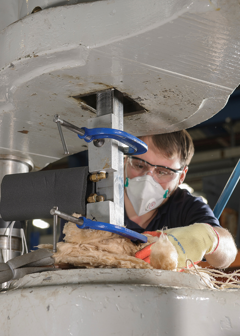 Figure 3 SENT specimen tested using localised cooling around the notch, (a) with liquid nitrogen cooling pipes clamped around the notch region