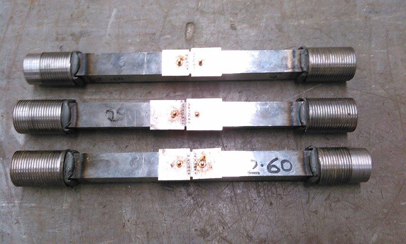 Figure 15 Friction welded threaded end SENT specimens, shown with shims attached to the notch mouth ready for the screw attachment of a double clip gauge before testing