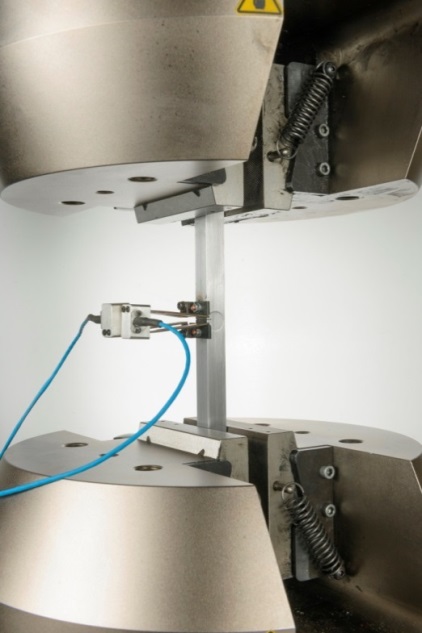 Fig. 1 SENT test specimen of square cross section instrumented with a double clip gauge ready for test under clamped loading at ambient temperature