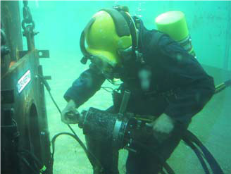 Figure 9 Diver loading a stud into the HMS3000 friction welding tool prior to positioning it into a magnet clamp for friction welding underwater (after Hsu et al 2005)