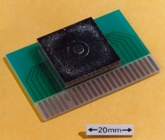 Circuit board with a metallised plastic cap welded over the chip