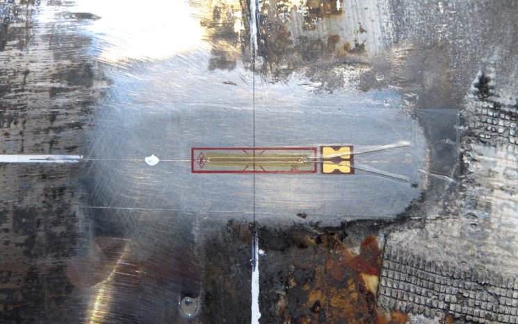 Figure 5 Uniaxial strain gauge applied to a pipe, and used to control and monitor axial strain applied during the resonance fatigue test.